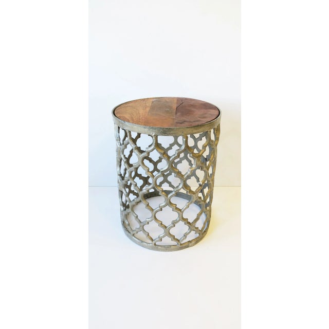 A silvered metal round drinks or side table with a Moorish design style, circa early-21st century. A silver-tone metal...