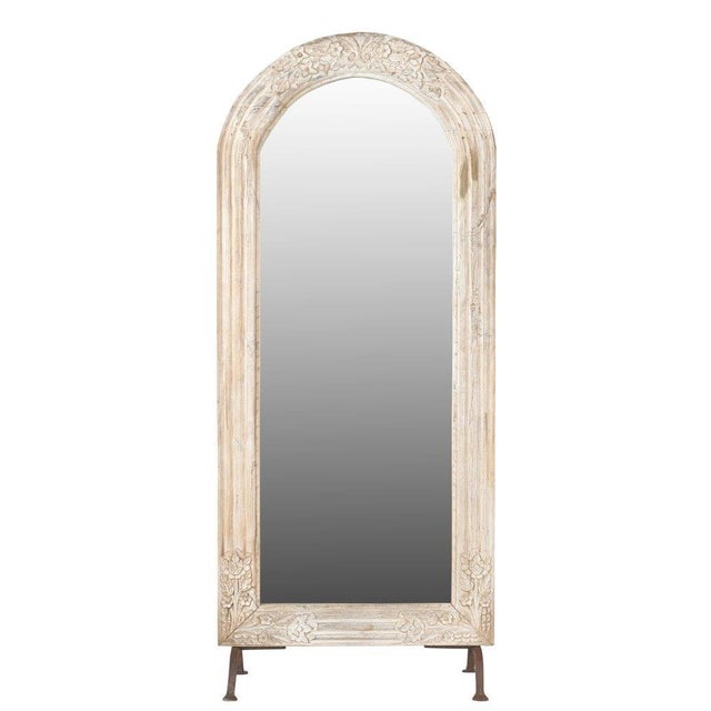 This Vintage Indian Carved and Bleached Teakwood Arched Top Mirror on Iron Legs is crafted from vintage teakwood window...
