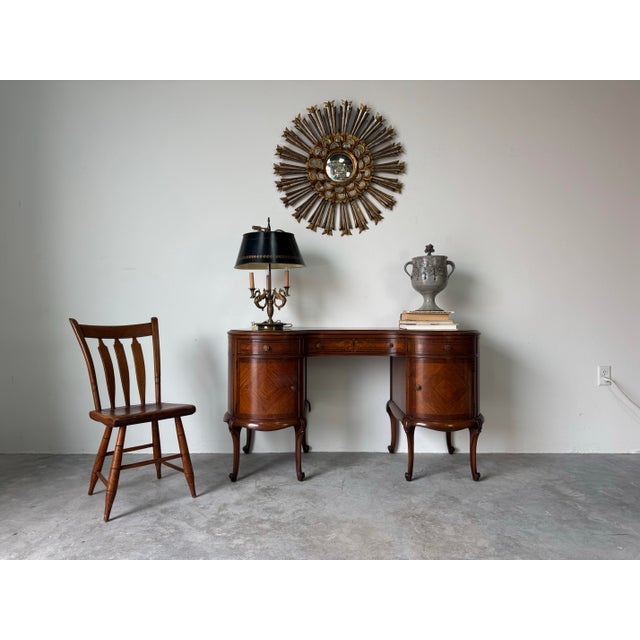 A beautifully crafted antique French Provincial kidney-shaped writing desk, executed in rich mahogany with elegant...