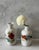 Pair of white ceramic bud vases with hand painted red, blue, yellow and green floral designs. Faded gold trim around the...