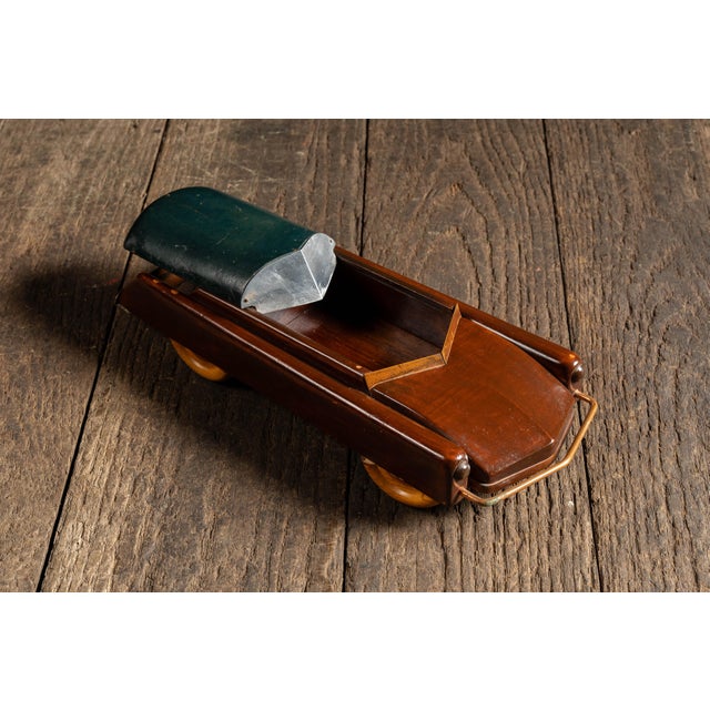 Figural tobacco box carved in the form of an early open-top automobile, closely resembling a 1920s touring car or roadster...