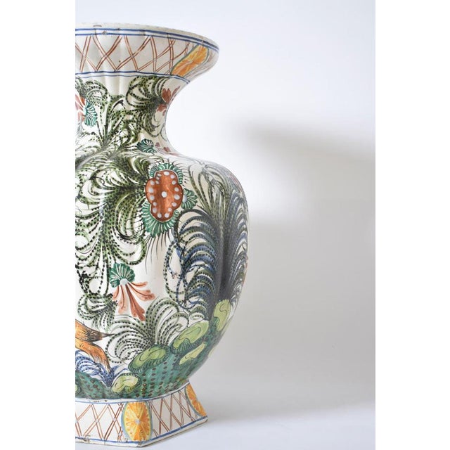 Large earthenware baluster vase with rotating polychrome decoration of exotic birds among lush vegetation. Italy, 1960s....