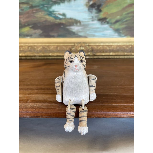 Charming hand-carved wooden tiger/cat figurine featuring articulated limbs strung with cord, allowing the legs and arms to...