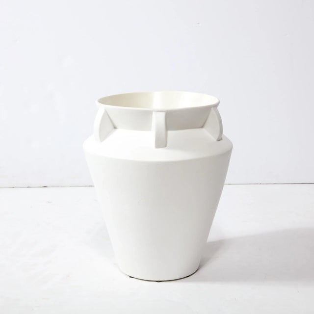 This elegant modernist urn form vase was realized in the United States during the latter half of the 20th century. It...