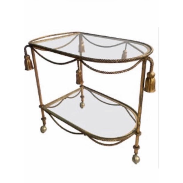 A fantastic Hollywood Regency Italian gilt rope and tassel bar or tea cart. Featuring distinctive twisted metal forged...