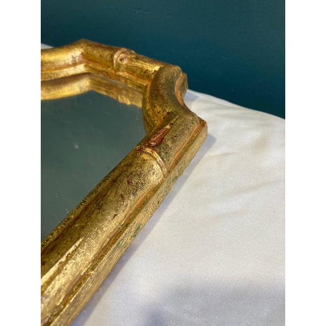 This vintage Florentia Italian wall mirror features a bamboo-inspired gilt frame with carved detailing and softly worn...