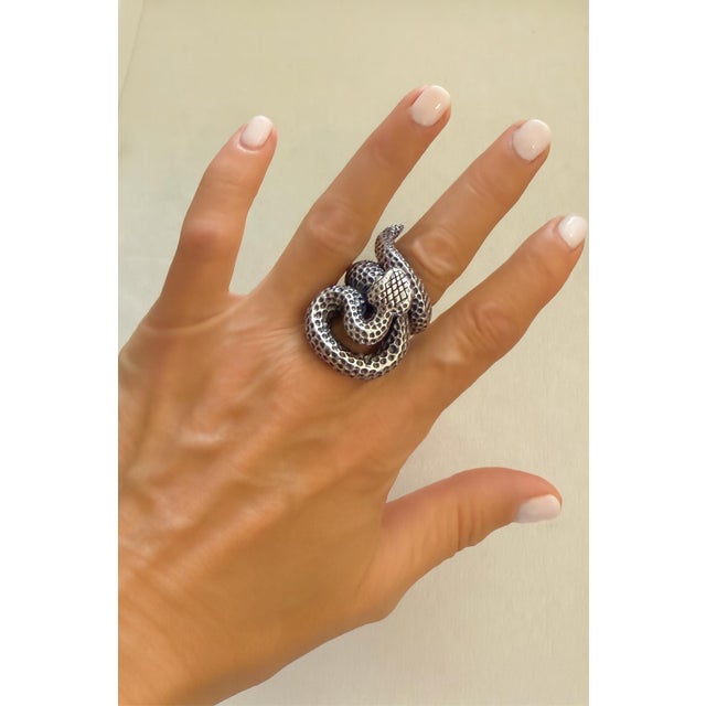 This bold sterling silver ring is designed as a coiled serpent, with a dimensional form and a textured surface that gives...