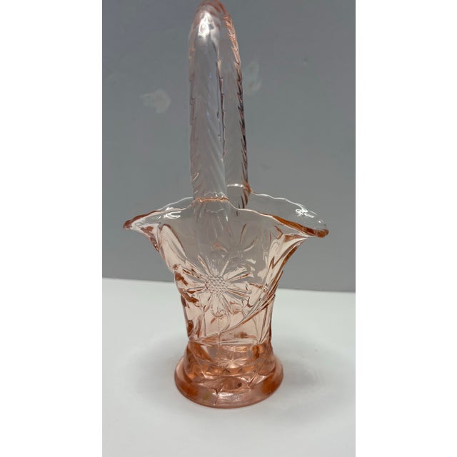 Elegant vintage American pressed glass basket in a soft blush pink hue, dating to the early 20th century. This sculptural...
