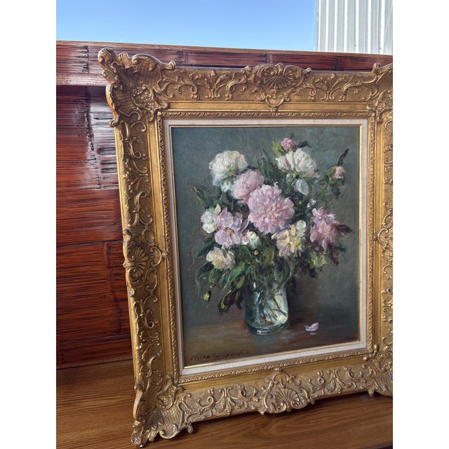This elegant still life depicts a generous bouquet of freshly cut pink and white peonies in a clear glass vase. Painted by...