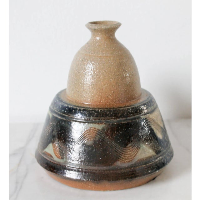 Vintage beige and blue studio art pottery bud vase with handle. Signed by the artist on bottom. One chip near base. Pictured.