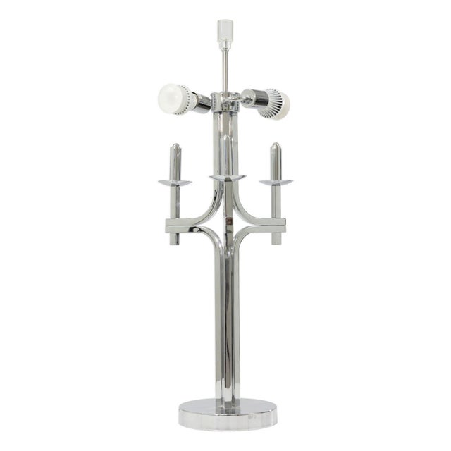A polished chrome table lamp in the style of Gaetano Sciolari. The lamp features a central vertical column rising from a...