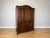 An elegant Antique French Louis wardrobe in Oak, displaying a rich dark finish, beautifully figured grain, shaped panelled...