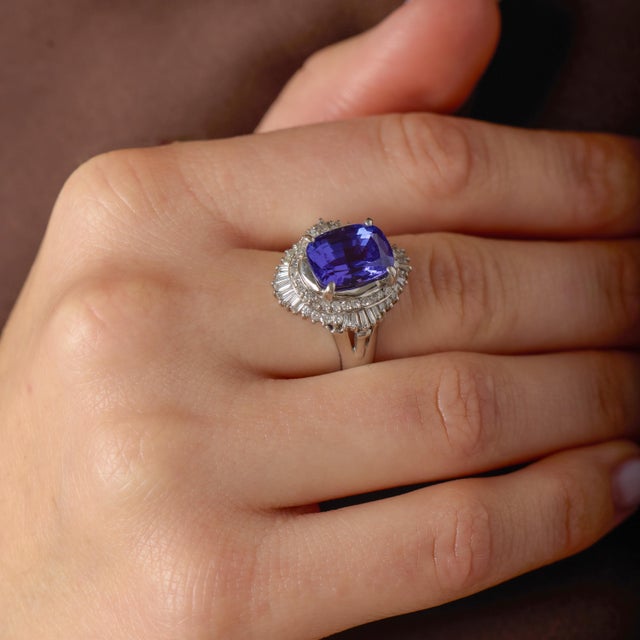 This striking vintage cluster ring is a dramatic and luxurious showcase of color, brilliance, and refined platinum...