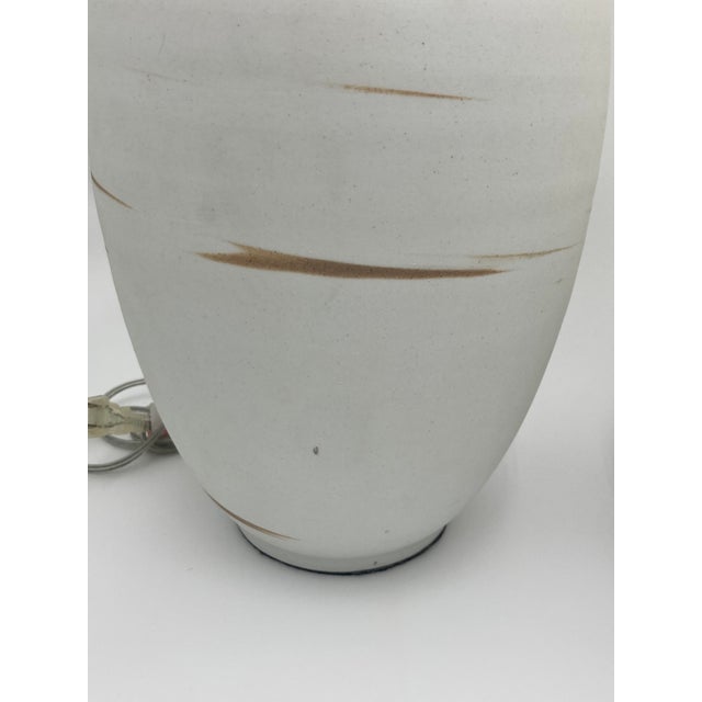 Mismatched pair of two ceramic table lamps with hand painted swoosh marks. These were purchased from an interior designer...