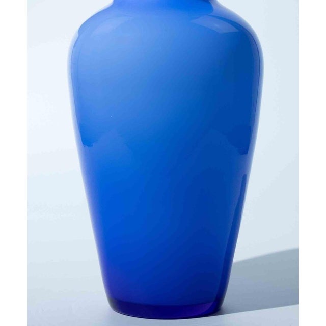 Elegant hand-blown art glass vase in a rich cobalt blue, featuring a smooth, minimalist surface and a beautifully balanced...