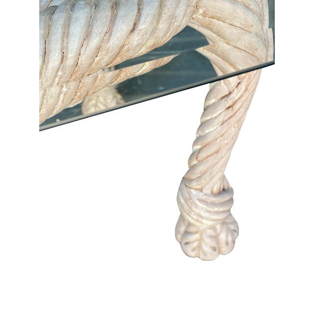 A vintage hand-carved rope wood coffee table in a limed or pickled wood finish. A simple glass top sits on top. Tasseled...