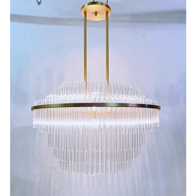 This is a custom made chandelier by LMD Custom Lighting Satin brass finish and glass rods. It has 10 candelabra base...