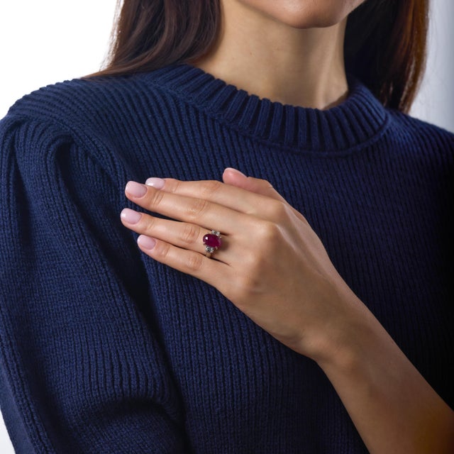 This exceptional vintage engagement ring is defined by the commanding presence of its remarkable Burma ruby, weighing an...