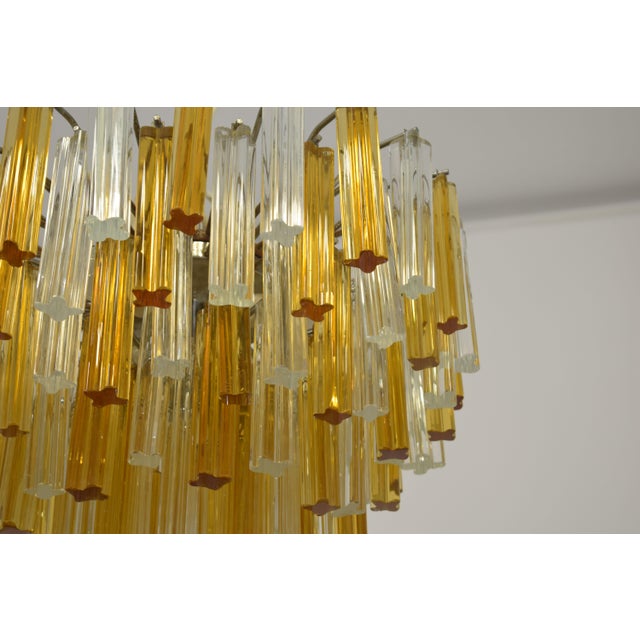 A striking 1970s Italian chandelier, attributed to Venini, featuring a refined composition of quatrefoil glass elements....