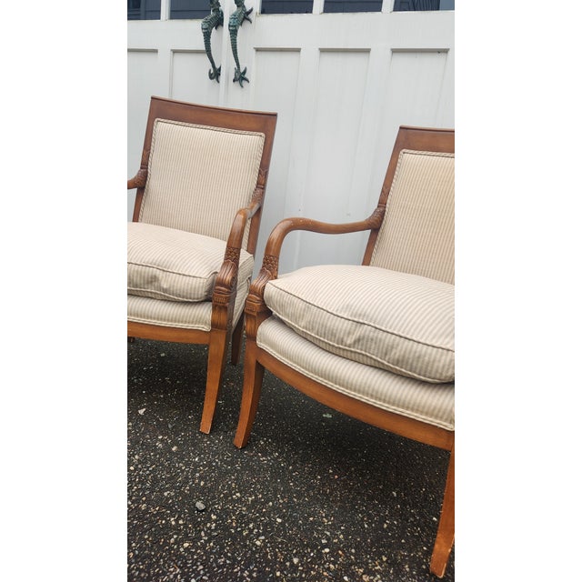 Handsome pair of vintage French Empire style armchairs featuring warm walnut-toned wood frames, square upholstered backs,...