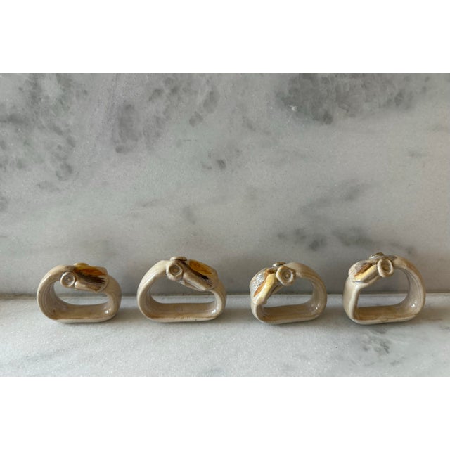 Set of 4 vintage hand painted ceramic napkin rings featuring an orange and brown shell design. Signed by the artist on the...