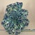 This hand-blown Murano style glass flower figurine features a vibrant green and blue color with a confetti style design....