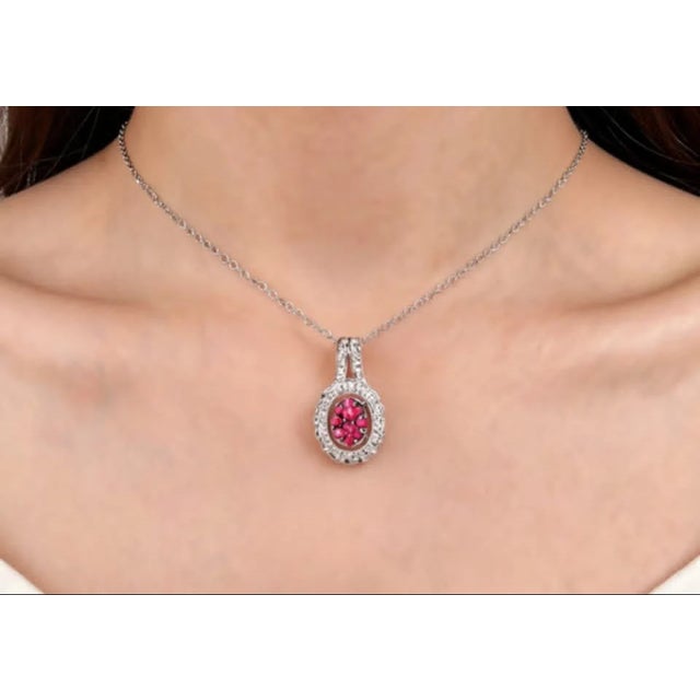 Elegant 14K white gold pendant featuring 10 natural round rubies and 16 brilliant round diamonds in a delicate filigree...