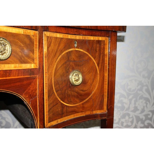 A really beautiful, early 19th century, English Hepplewhite, inlaid mahogany sideboard, circa 1800. The serpentine top is...