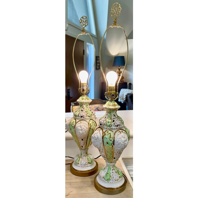 This stunning pair of mid-century, Italian Capodimonte table lamps feature high-relief, molded figurative details...