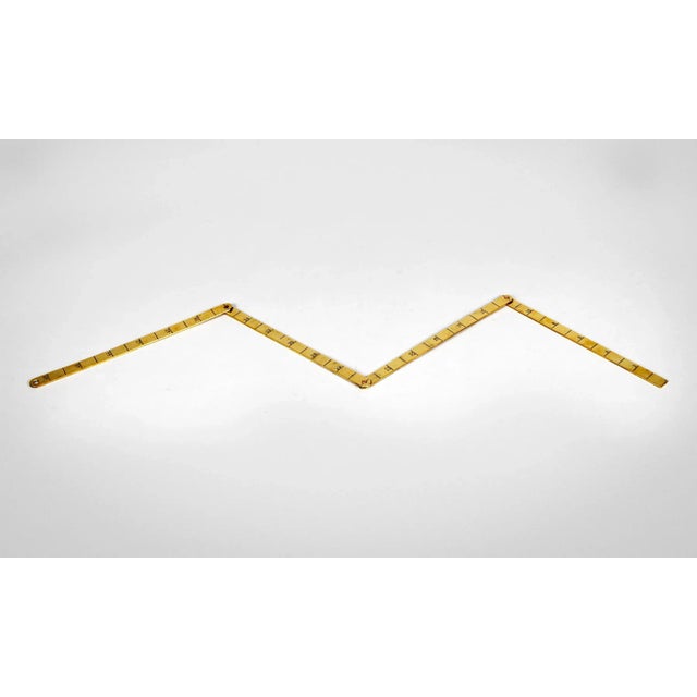 Antique brass 48″ folding ruler, separated in 12″ sections, joined by copper rivets.