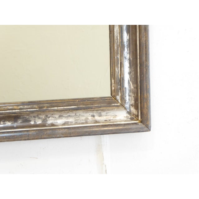 This 19th Century silverleaf mirror has an old patina with bright silver and pewter tones and measures 25.75"H x 21.5"W.