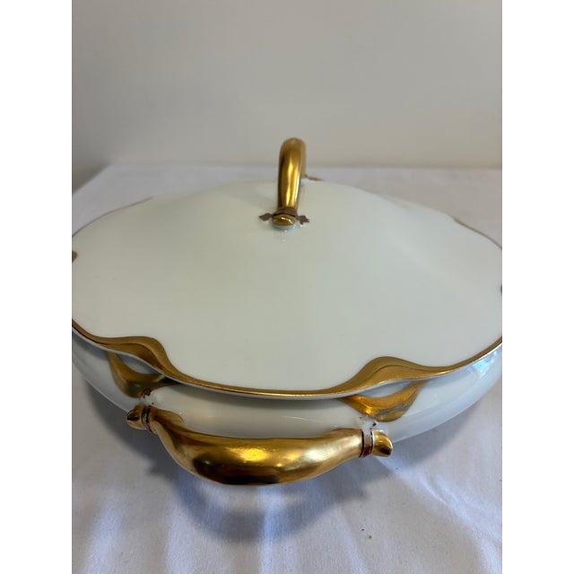 An elegant antique covered tureen by Haviland & Co. Limoges, featuring soft white porcelain with striking gold Art...