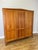 A handsome Vintage French Louis wardrobe crafted in oak, featuring a broad three-door form, warm natural finish and...