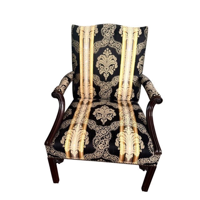 Pair of mahogany library chairs crafted in the Chippendale style with decorative carved arms and stretcher cutouts around...