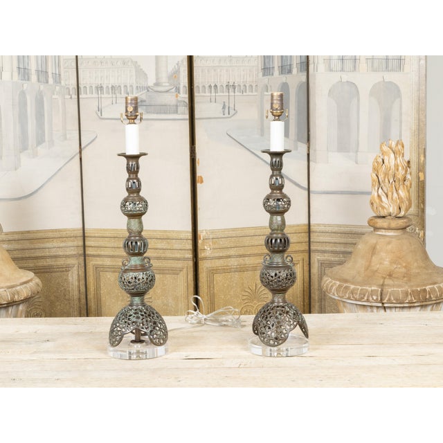 A pair of Asian bronze table lamps from the mid-20th century, with openwork décor, single lights and custom lucite bases,...