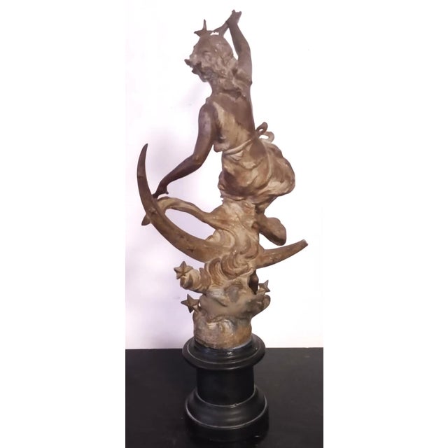 Elegant antique French bronze sculpture representing “La Nuit” (The Night), depicted as a graceful female figure seated...