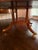 A vintage 72" round mahogany banded dining table by Councill Furniture. It features inlaid trim, brass feet and the...