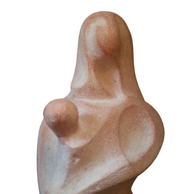 Abstract semi cubist sculpture of a mother with child,. with a form outlined using simple curves and lines, harmoniously...