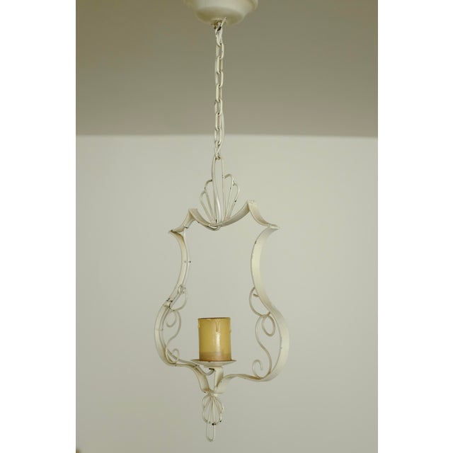 1950s White painted Metal Pendant with organic details from Sweden. One candle shaped light source with a frame with...