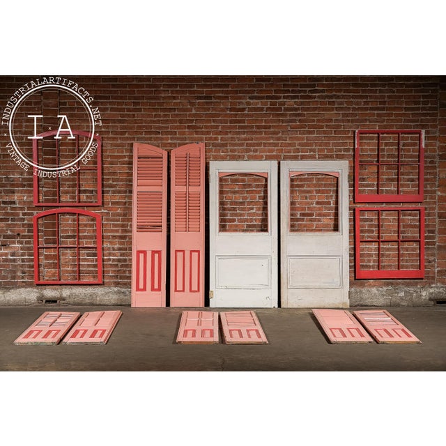 A vibrant, salvaged architectural ensemble sourced directly from New Orleans, comprising doors, shutters, and window...