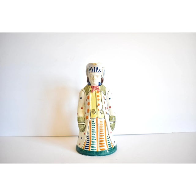 An Italian majolica pitcher in the form of an eighteenth-century man with hand-painted details. Marked "Italy" on the...