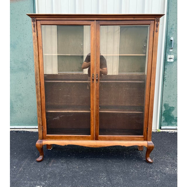 A beautiful antique bookcase made of solid cherry in a Queen Anne style. Features two swinging glass doors, behind which...