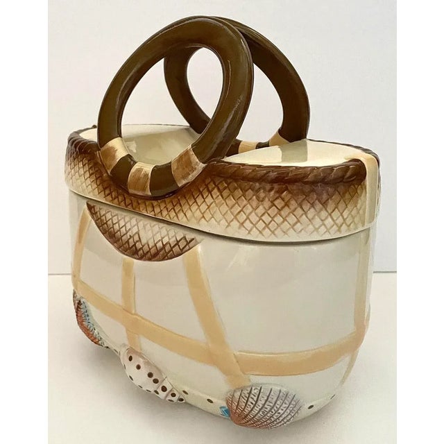 Beach bag shaped ceramic cookie jar with lid. Both front and back of cookie jar have identical raised and painted details...