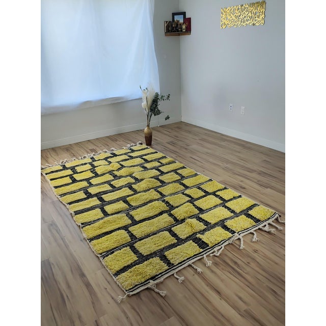 One-of-a-kind handwoven Moroccan rug. A saturated chartreuse ground divided into a brick-like grid by black and white...