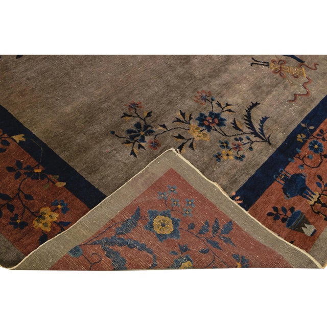 Beautiful antique Art Deco Chinese hand-knotted wool rug with a gray field. This Chinese rug has a tan frame and...
