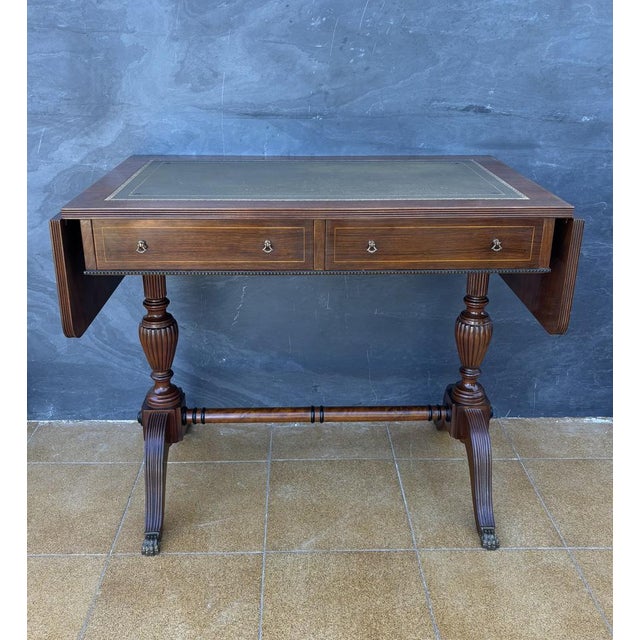 Spanish Regency Revival drop-leaf writing table crafted in solid wood, mid-20th century. Inspired by early 19th-century...