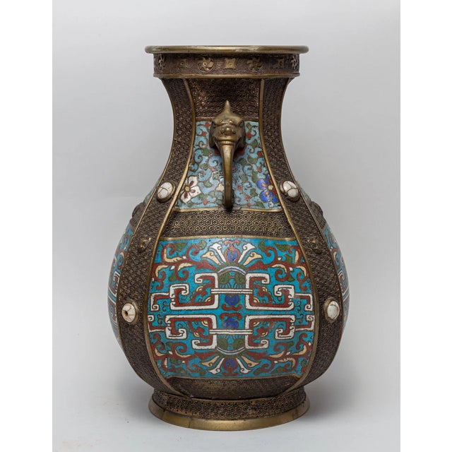 The vase exterior is cast with flower scrolls on turquoise ground, set with raised vertical bands and two handles, the...