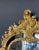 Elegant mirror in hand-carved gilded wood with botanical details that intertwine with two mythical looking creatures on...