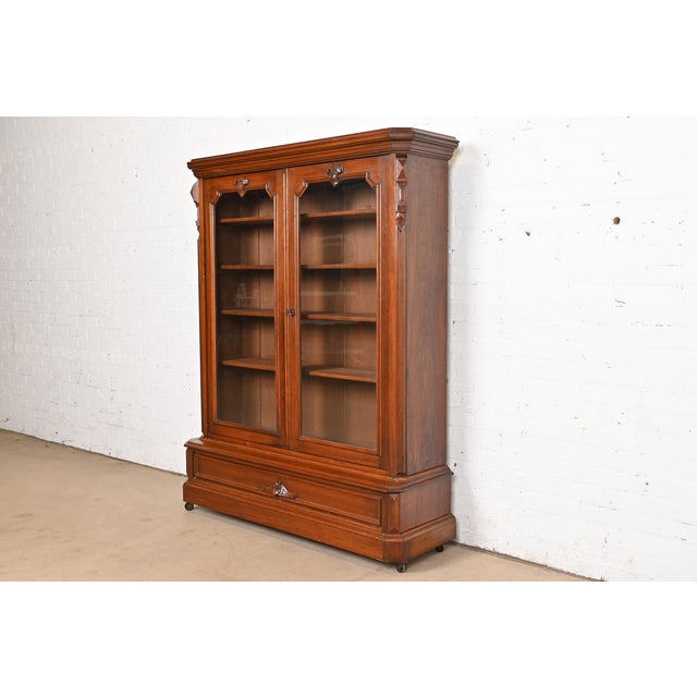 A gorgeous antique Victorian bookcase cabinet In the manner of Herter Brothers USA, Circa 1880s Carved solid walnut, with...