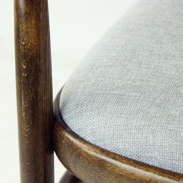 Beautiful, elegant armchair made of a bentwood oak construction with the seat and backrest in light grey upholstery. The...